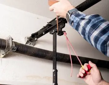 Top Doors technician repairing a garage door spring and track in Vaughan